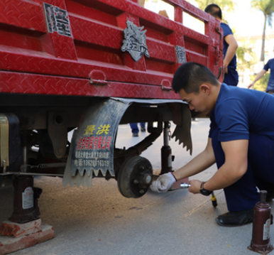 消防隊(duì)員用液壓千斤頂給三輪車更換輪胎