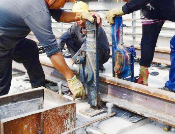 起道機(jī)千斤頂協(xié)助地鐵工人安裝鋼軌緊固件